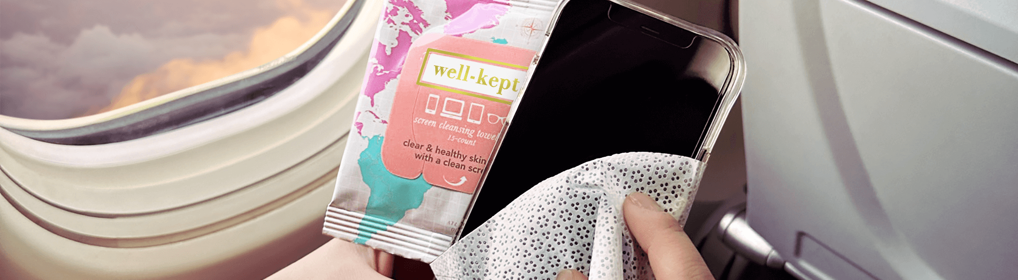 Image of person wiping their phone screen on a plane with Well-Kept wipes.