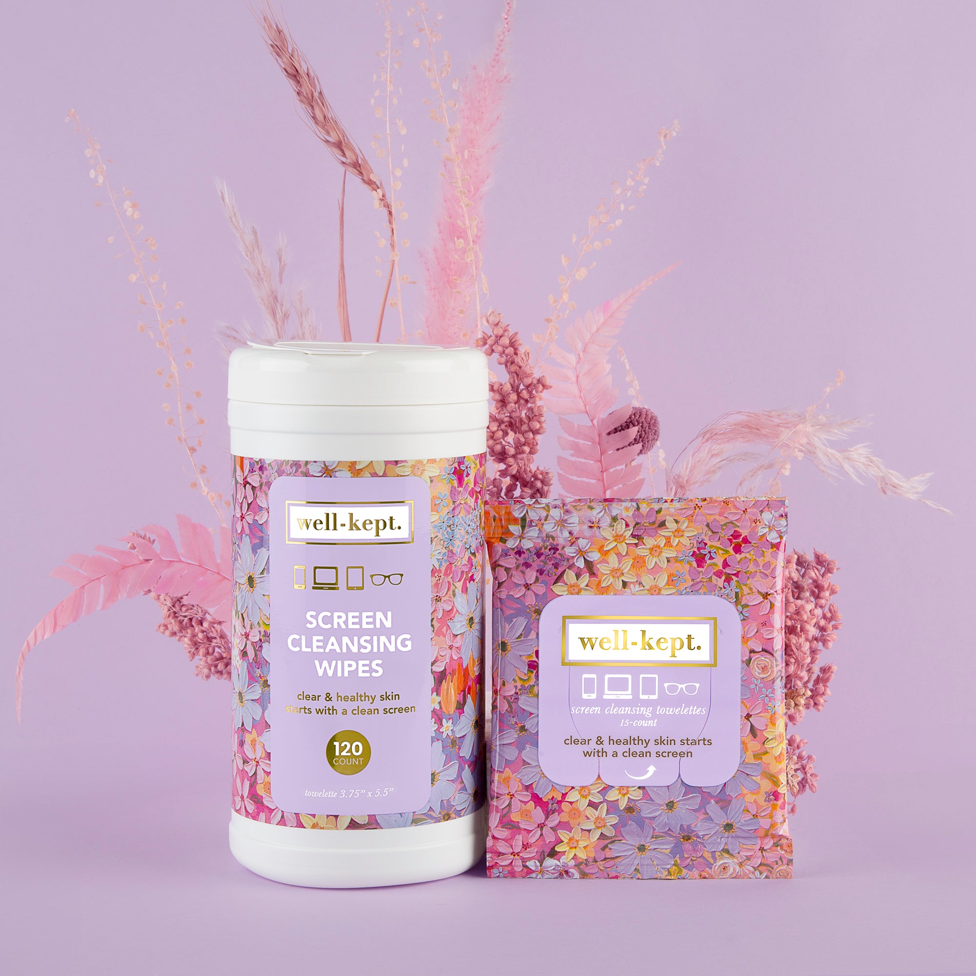 The NEW SIZE - FLOWER POWER CANISTER features pre-moistened electronics cleaning wipes in floral packaging, displayed among pink flowers on a purple background—ideal for stylishly removing tech germs.