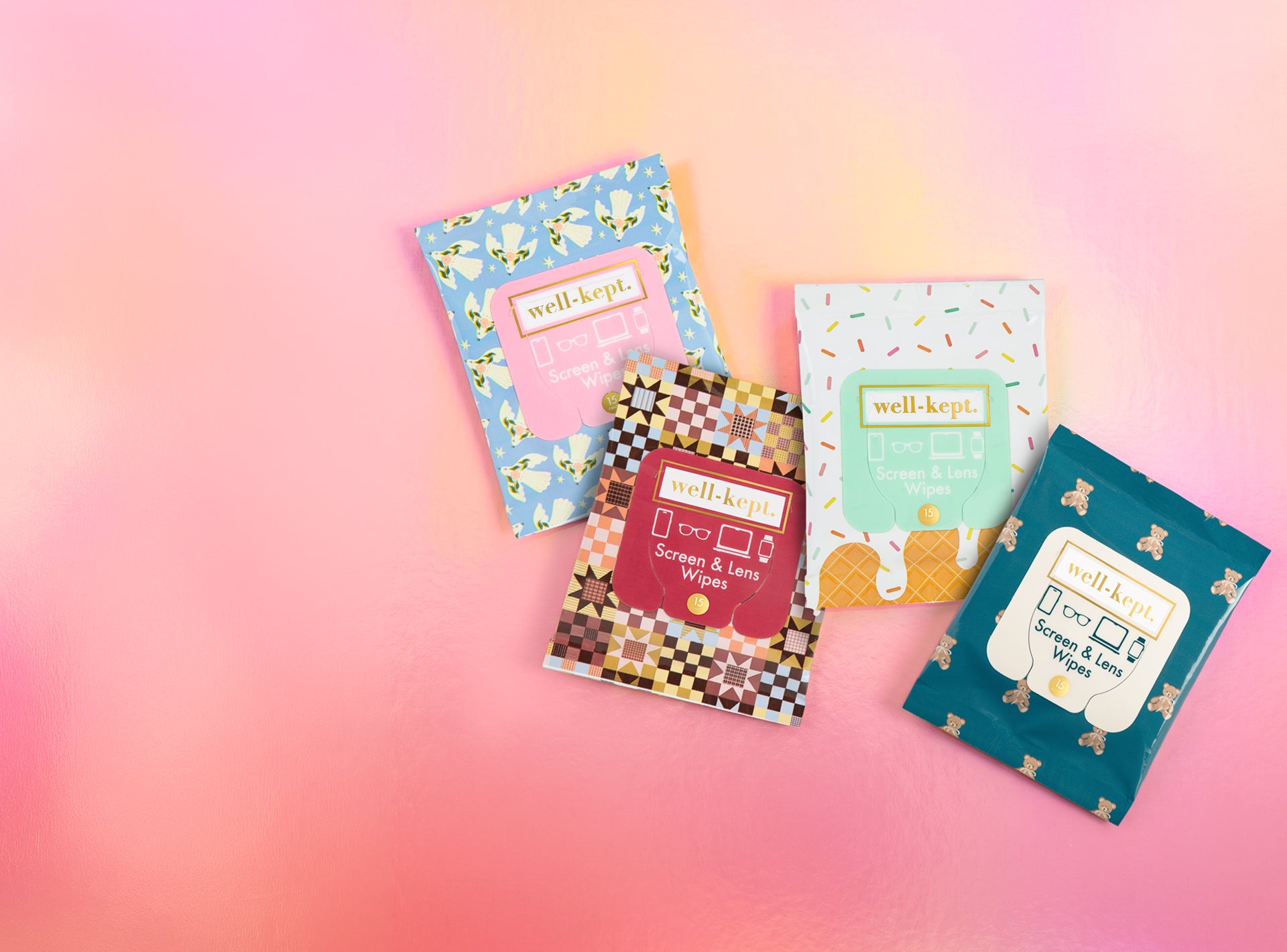 Four Well-Kept screen and lens wipes packs in checkerboard, floral, sprinkle, and teddy bear patterns on a pink gradient background