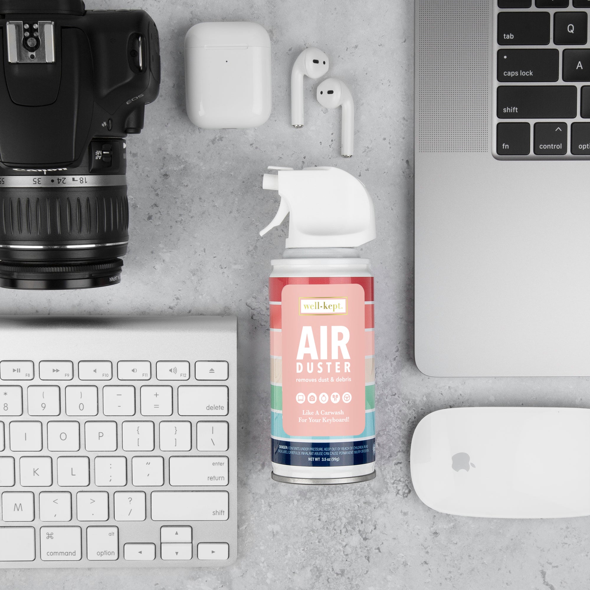 Well-Kept Air Duster can on a desk with a camera, wireless earbuds, a keyboard, and a mouse